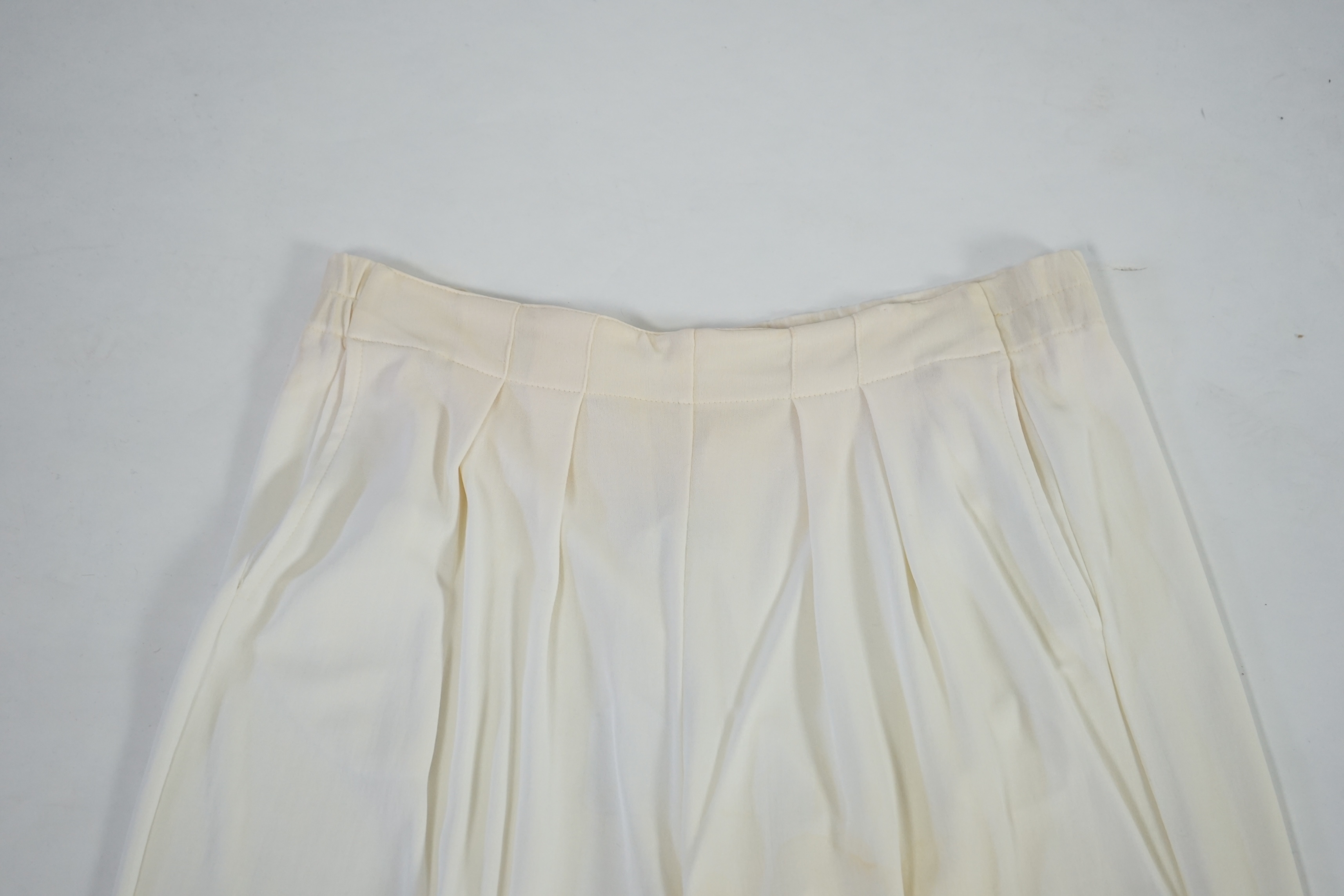 A La Perla white trouser lounge suit, a black jacket lounge jacket, a fawn silk dress and a white embroidered shirt dress. Approx Size L Proceeds to Happy Paws Puppy Rescue